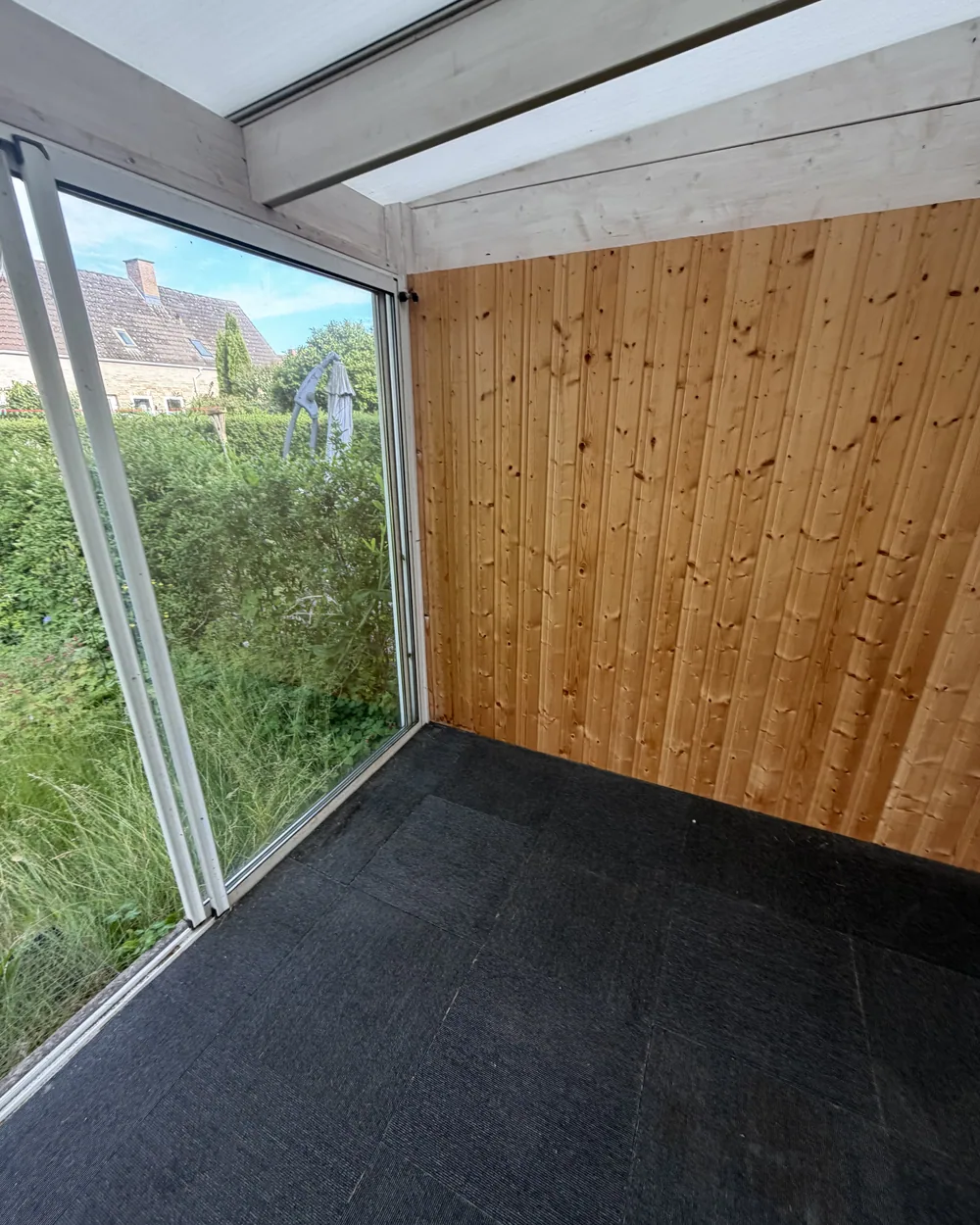 Overdækket terrasse med glasparti og træbeklædning